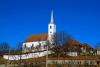 A white church and spire with walls for defence - Fortified church