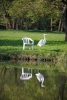 A great egret (Ardea alba) next to a plastic garden chair - Sit down please