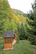 Wooden well in a mountain garden surrounded by pines - Draw well