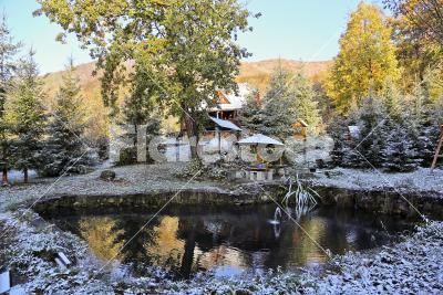 The first snow - Mountain garden with a fishpond covered by snow
